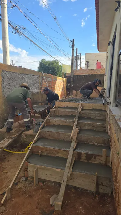 Equipe concretando escada em obra residencial