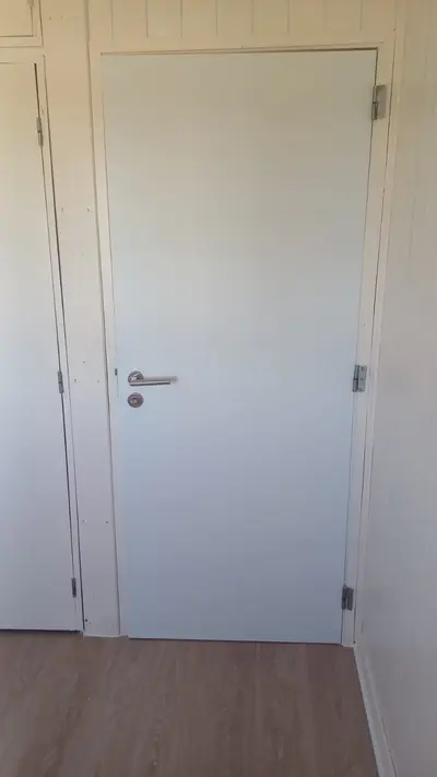 Porta branca instalada com acabamento de lambri