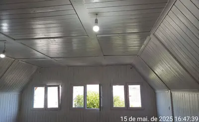 Sótão reformado com lambri branco e janelas